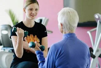 a fitness instructor and an elderly woman working out