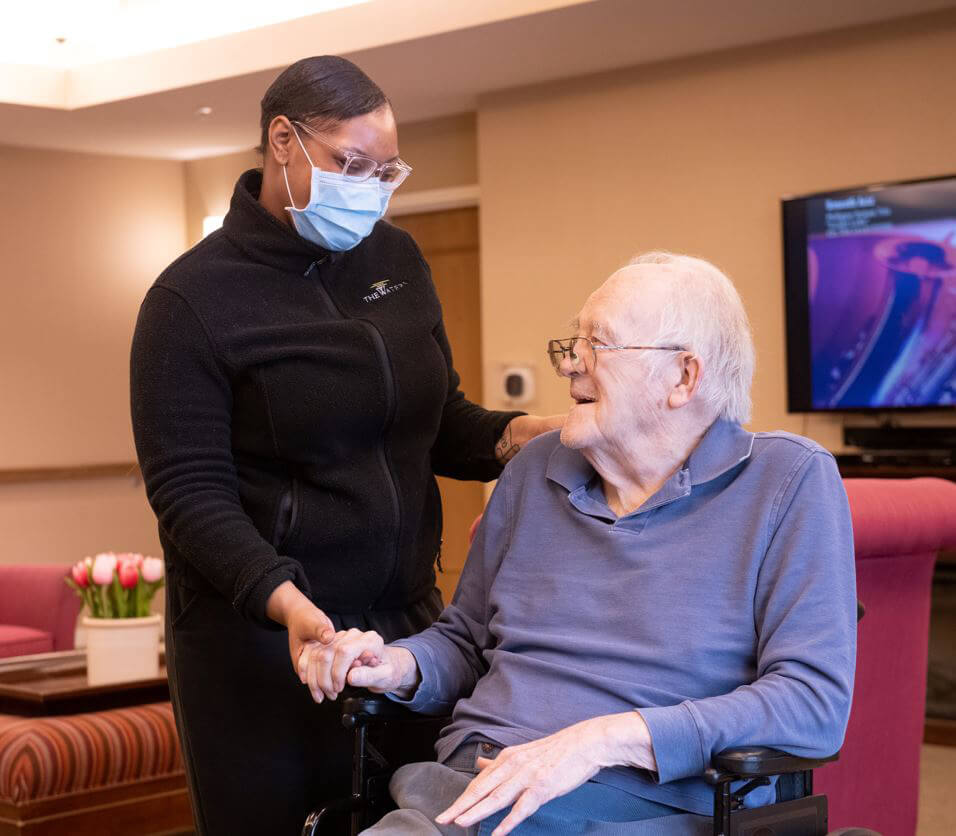 a staff member of the waters embracing an elderly man