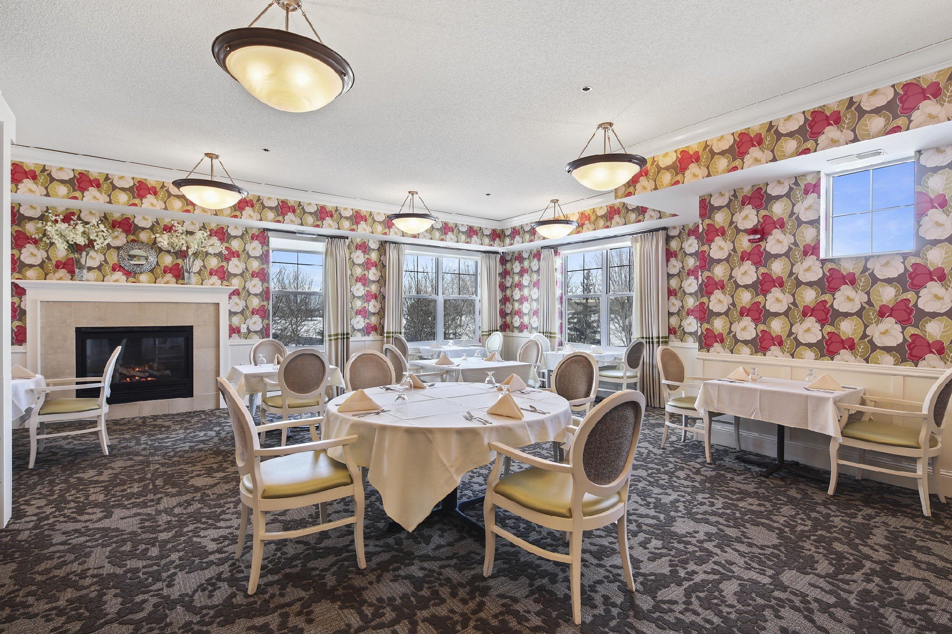 A colorful dining room with many tables and chairs organized nicely across the room.