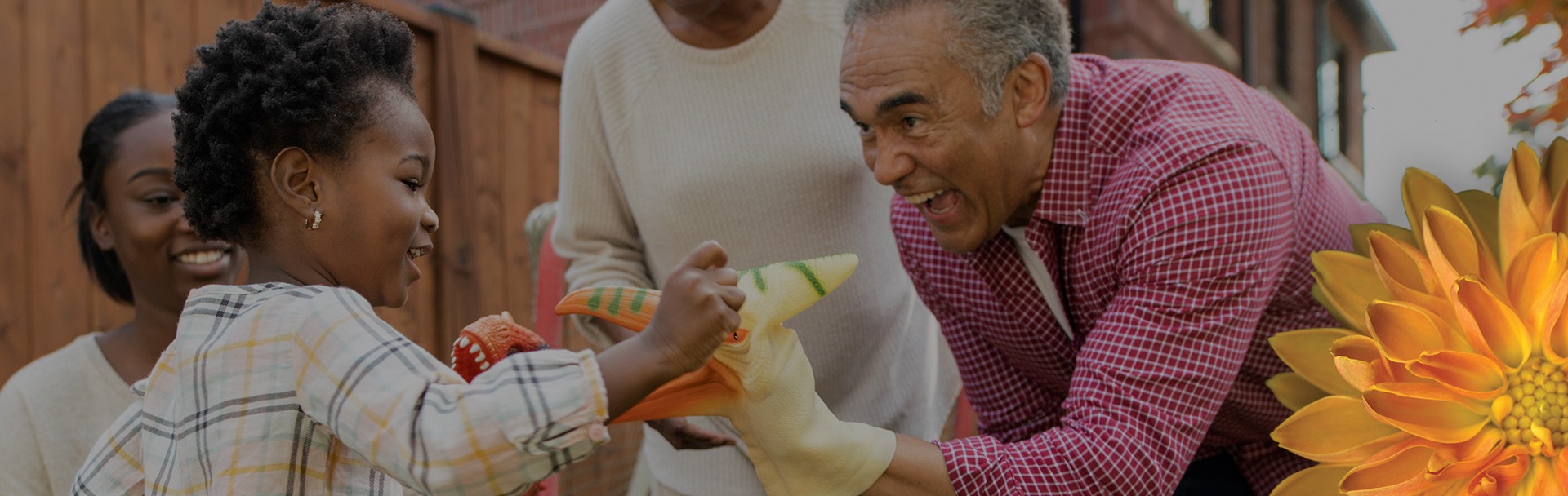 older man smiling and playing with toys with a child