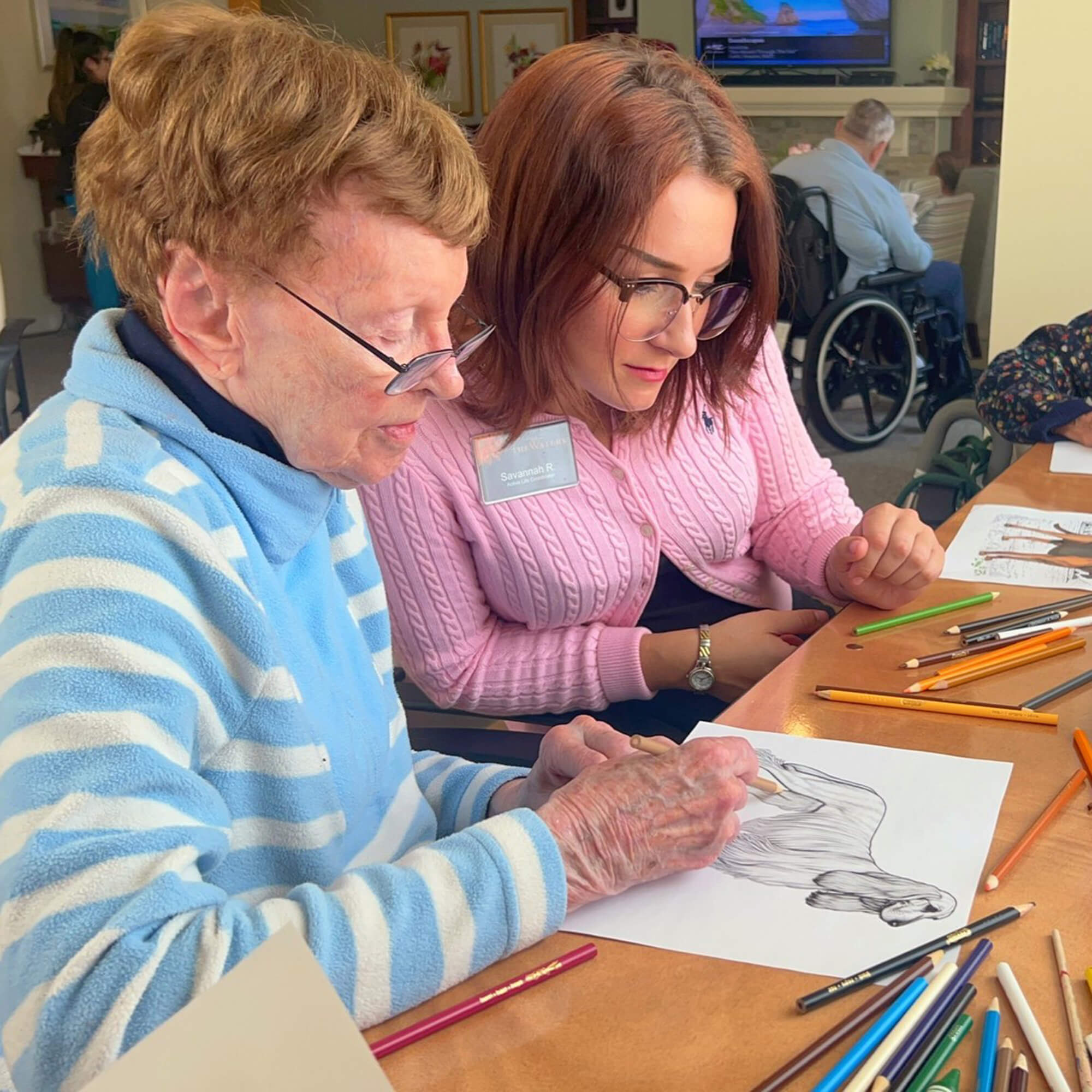 team member reviewing a residents drawing of a dog