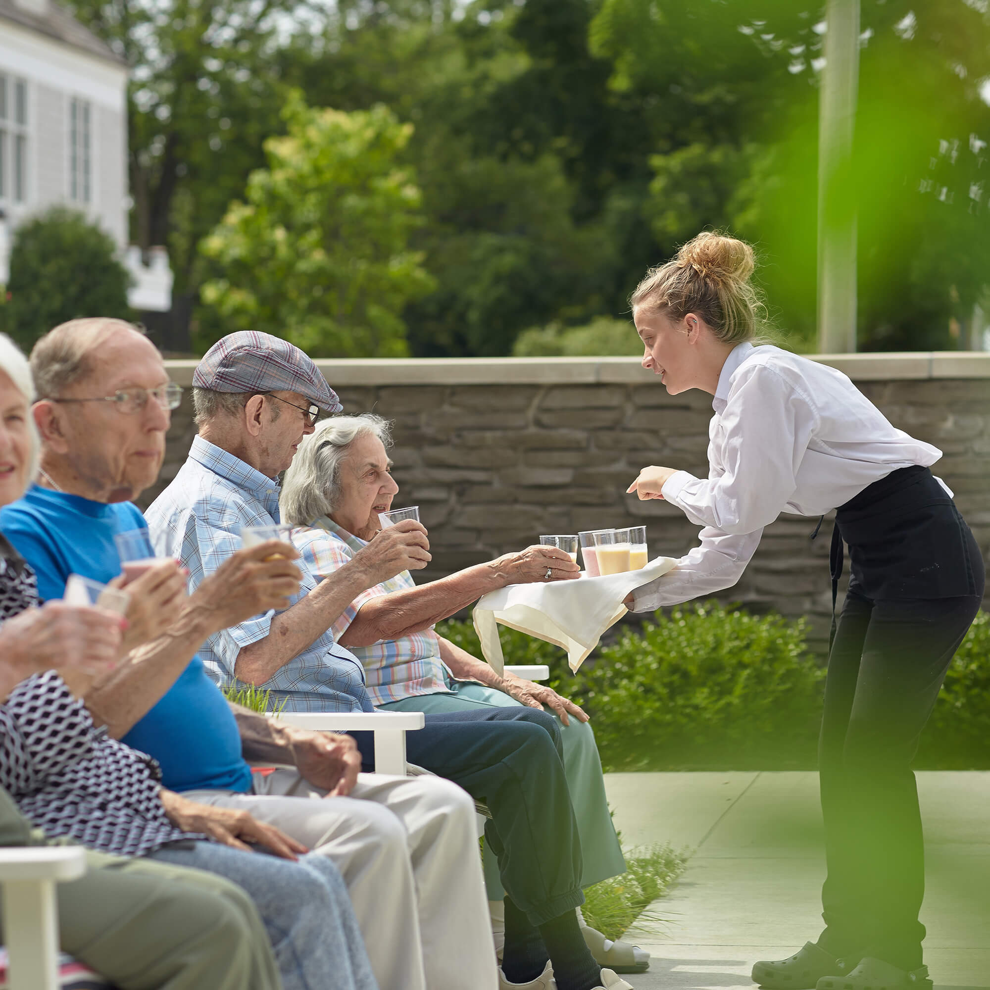 a team member serving drinks to residents outside