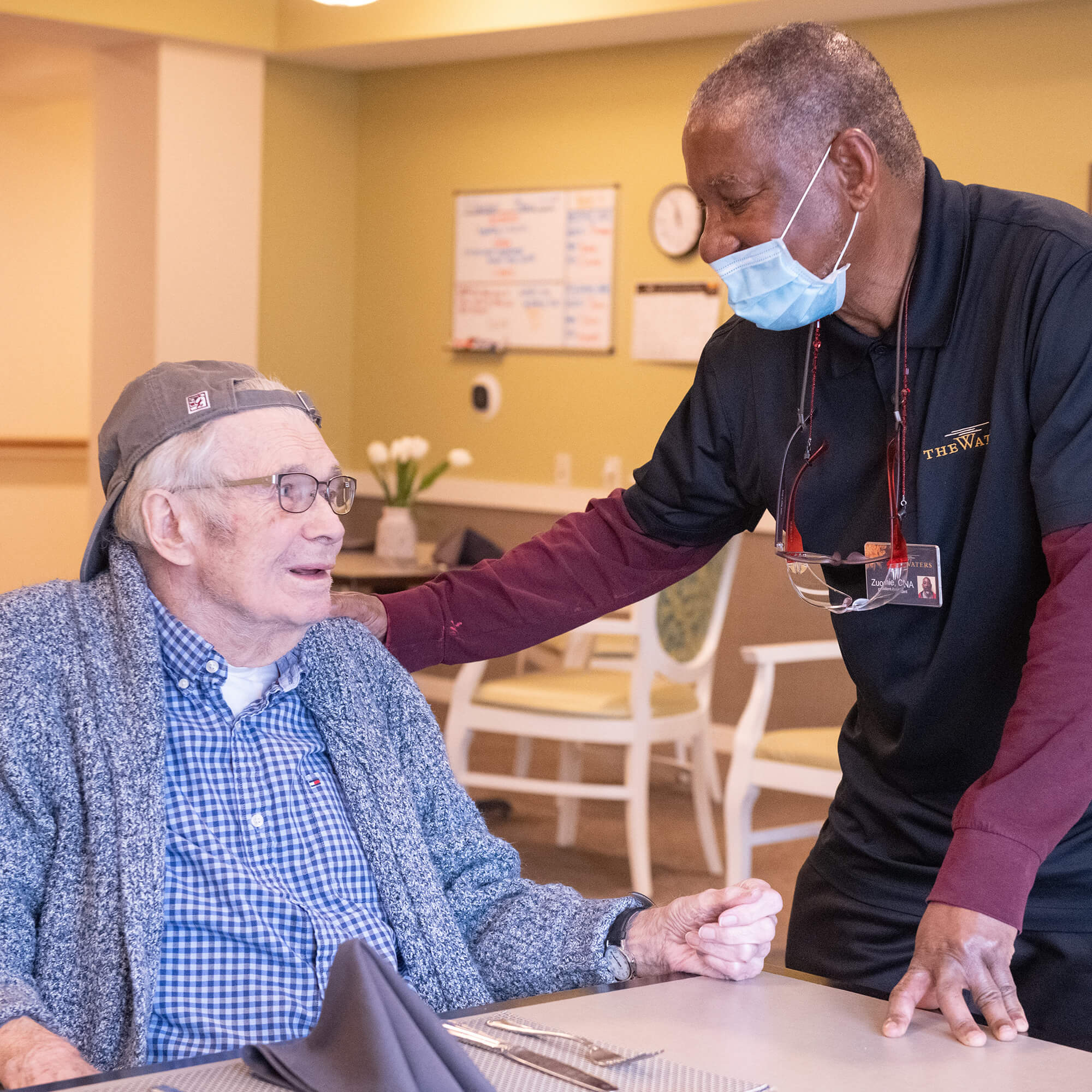 a team member patting a resident on the shoulder