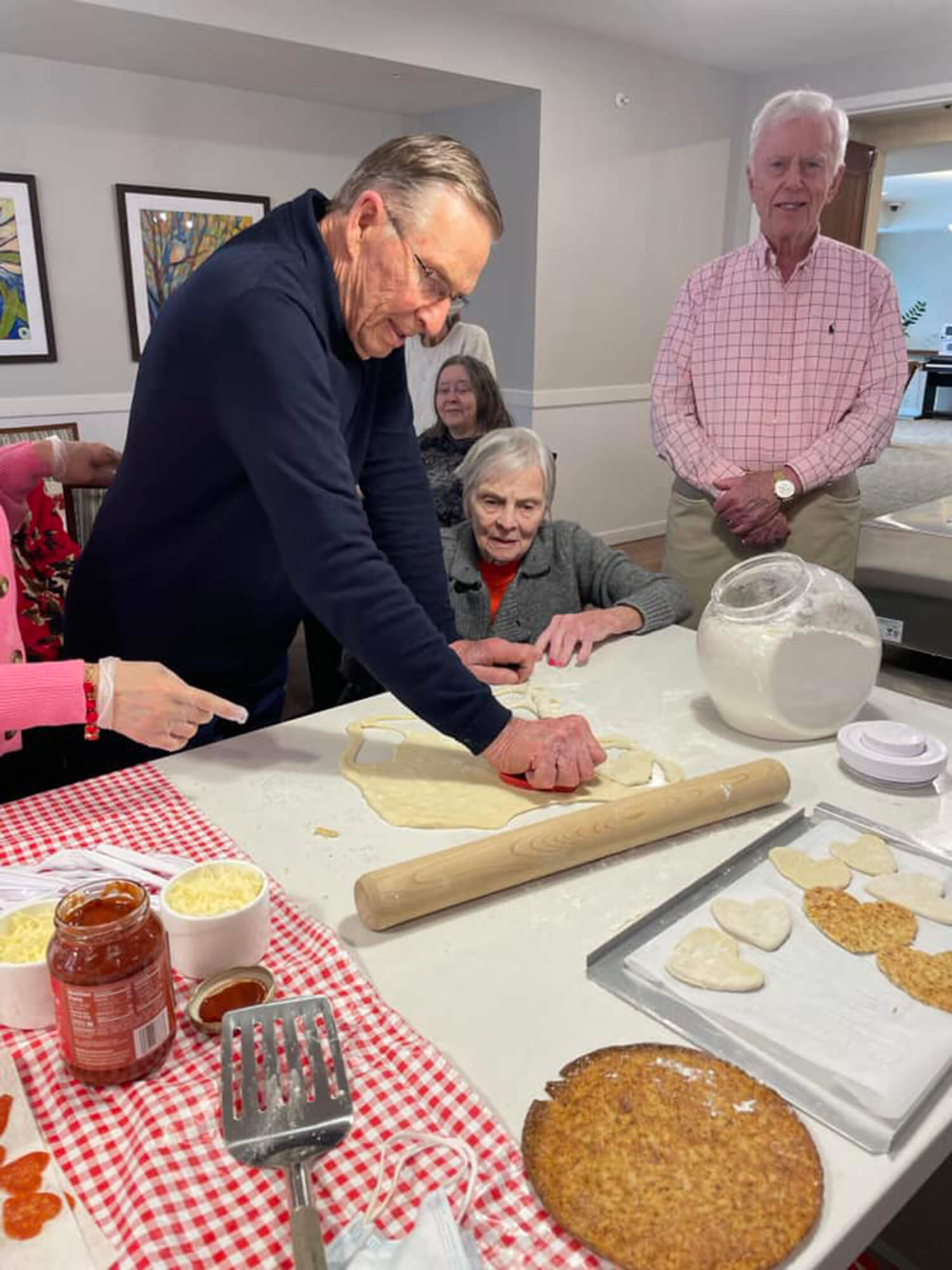 Seniors actively participating in a cooking class, rolling dough for pastries in Edina, MN.