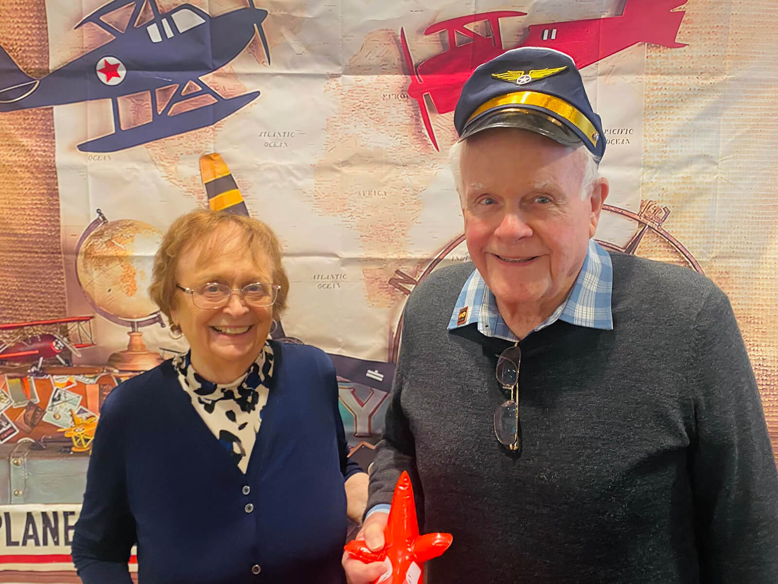 A senior couple at The Waters on Mayowood celebrating Aviation Day, adding a touch of adventure to senior living.