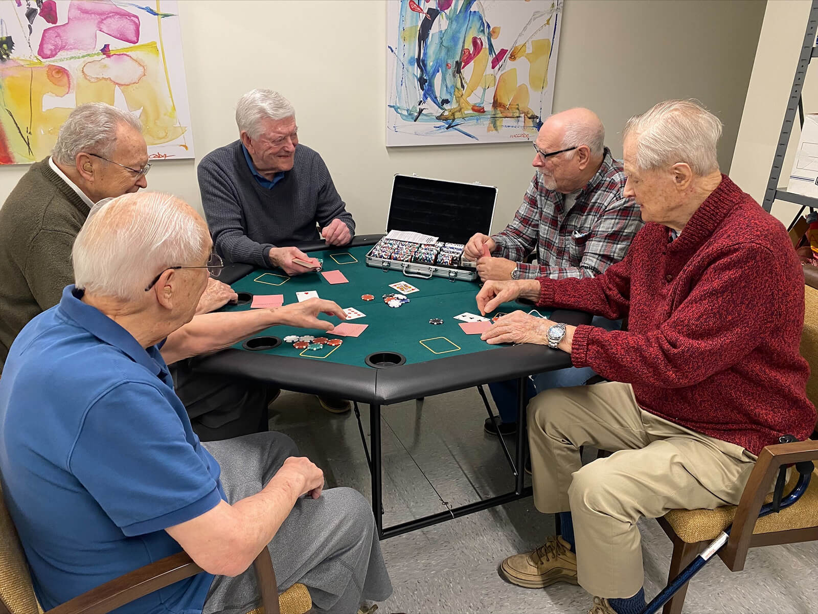 Group of senior men playing cards in a social event at The Waters of McMurray