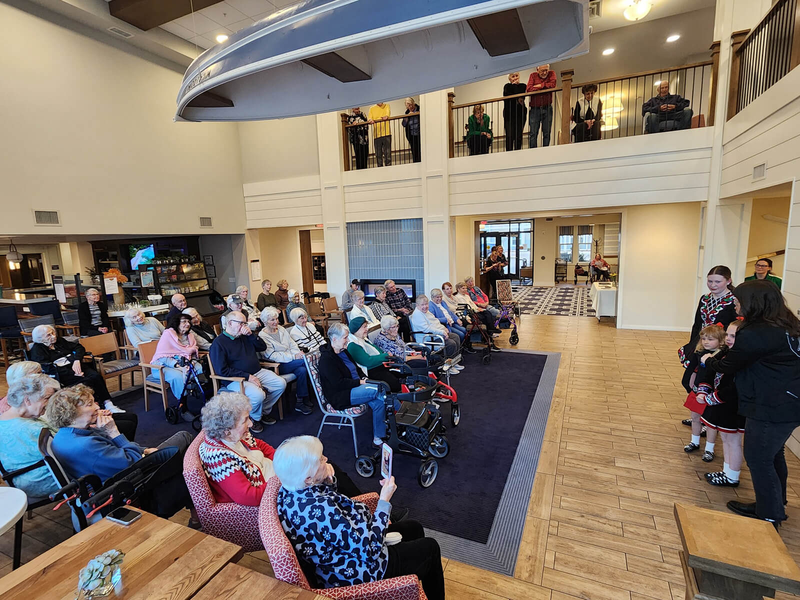 Residents of The Waters of Excelsior enjoy a live musical performance in the spacious community lounge, illustrating the active social life at the residence.