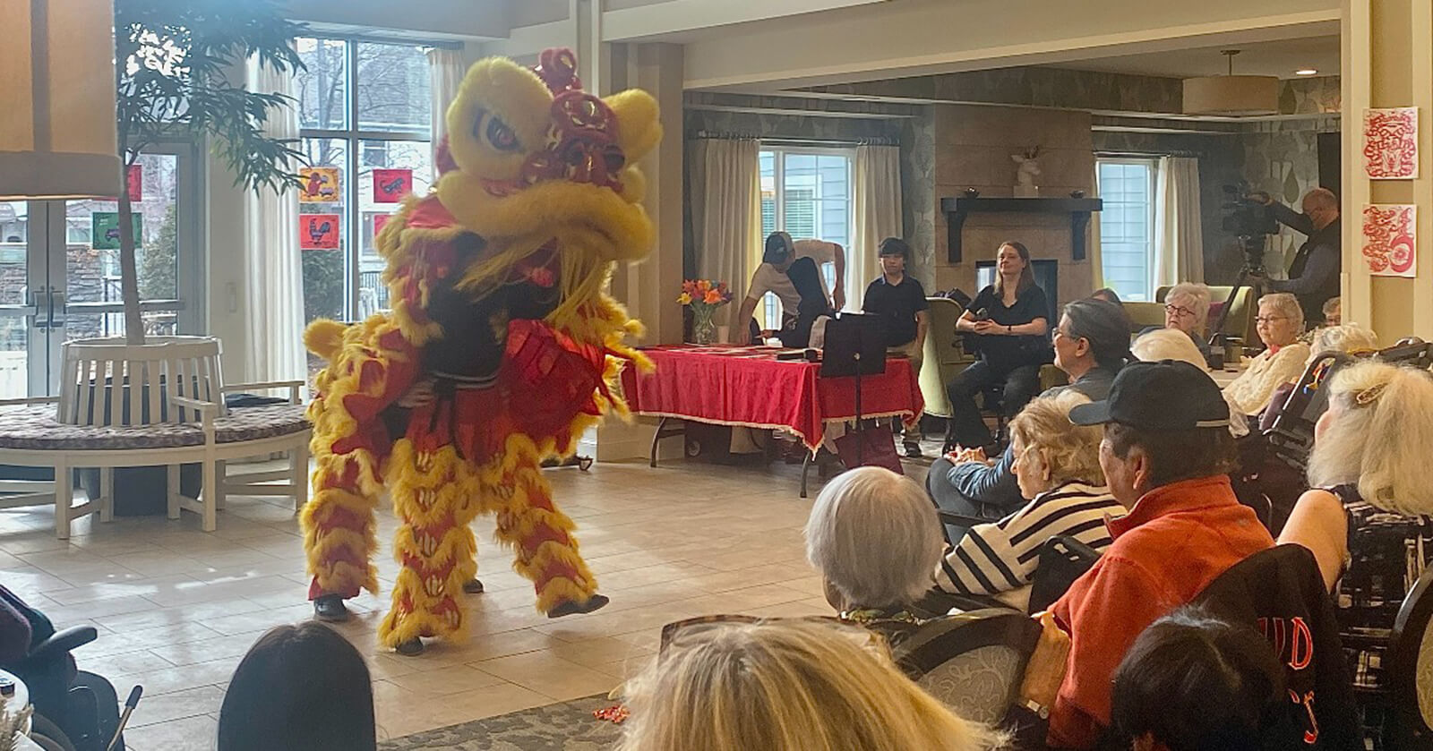 Residents of The Waters on 50th in Minneapolis watching a vibrant lion dance performance during a cultural event.