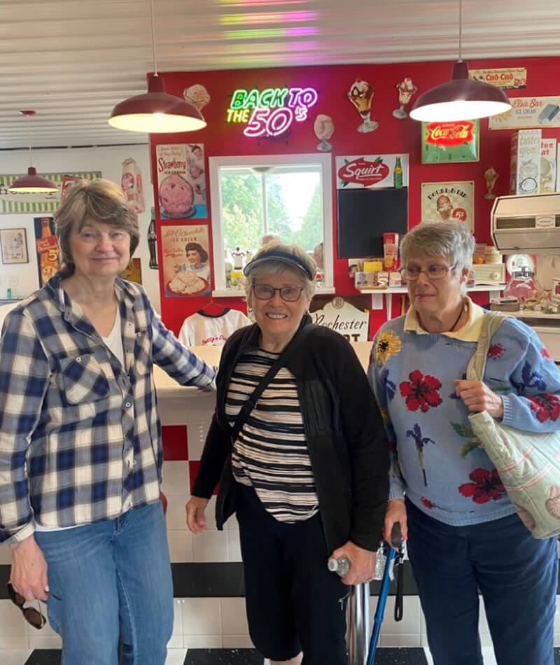 Residents of The Waters on Mayowood on a nostalgic outing to a 50's style diner, illustrating the facility's diverse activity program.