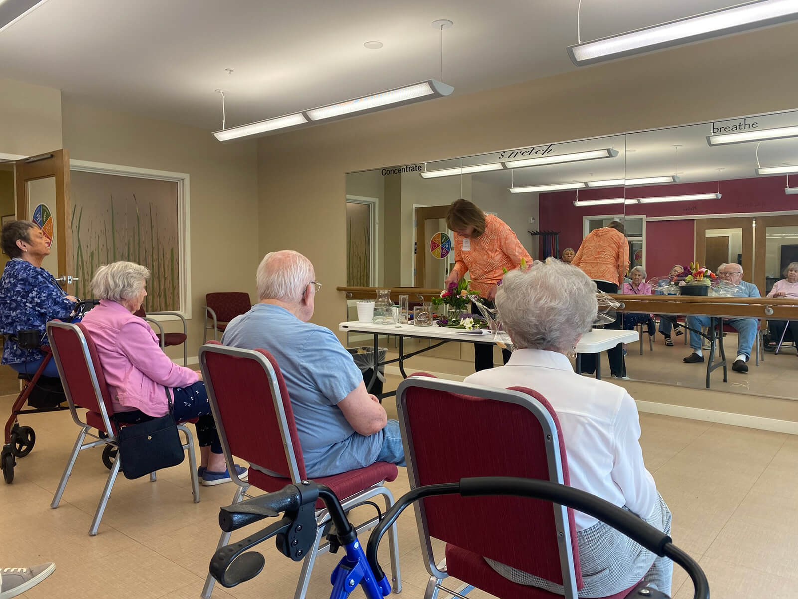 Seniors at The Waters on 50th in Minneapolis participating in a flower arrangement class, engaging in creative activity.
