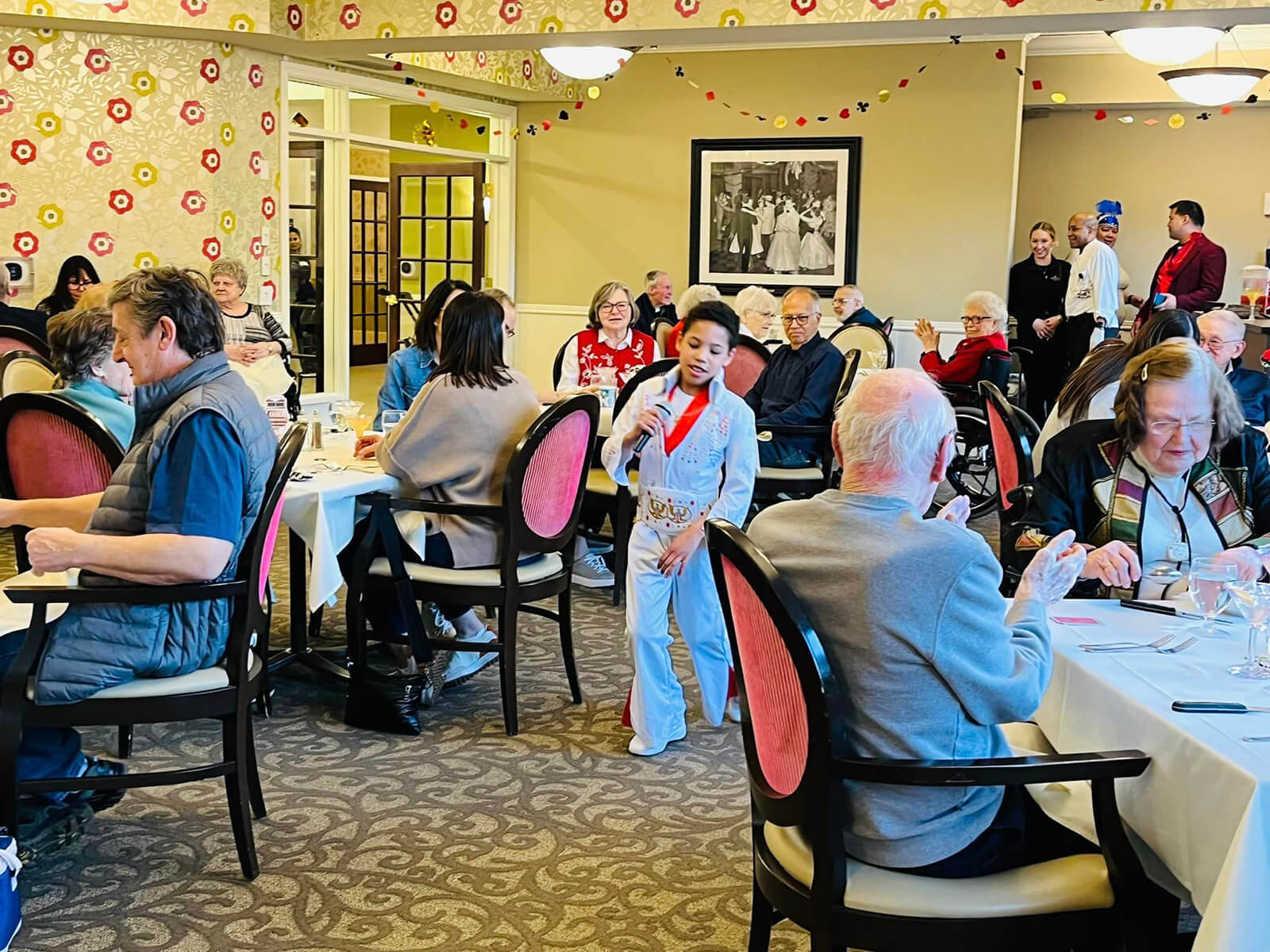 A kid performing as Elvis for a room of Seniors at The Waters of Eden Prairie