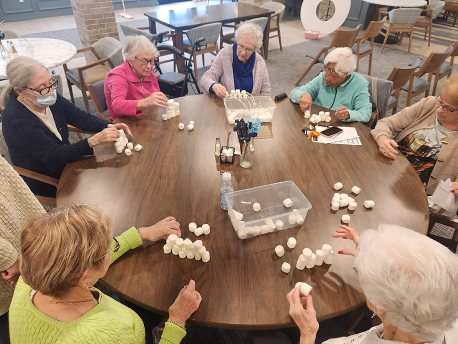 Residents of The Waters of Pewaukee participating in a marshmallow tower building game, encouraging teamwork and mental agility.