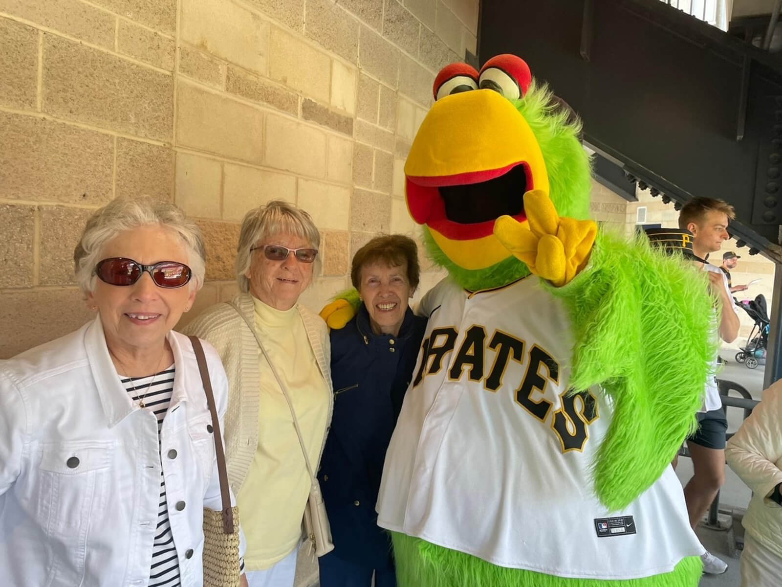 Senior residents of McMurray enjoying an outdoor baseball event with mascot.