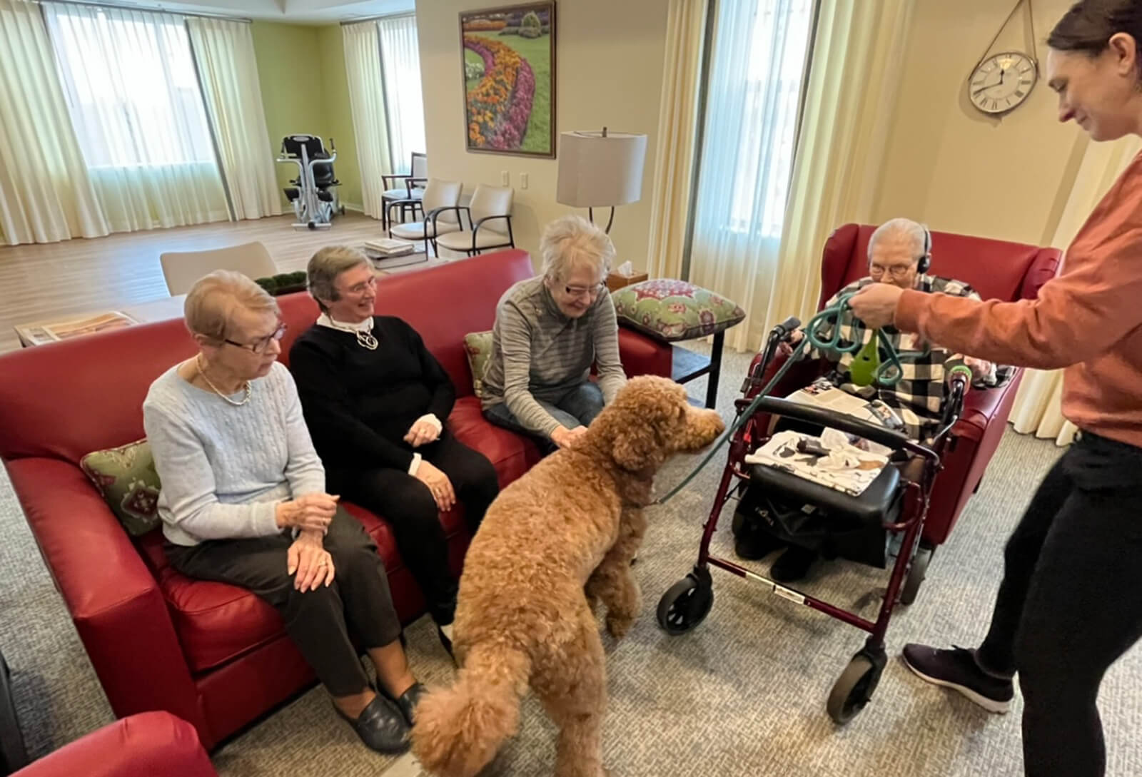 Residents petting a therapy dog during a visit to The Waters of Highland Park.