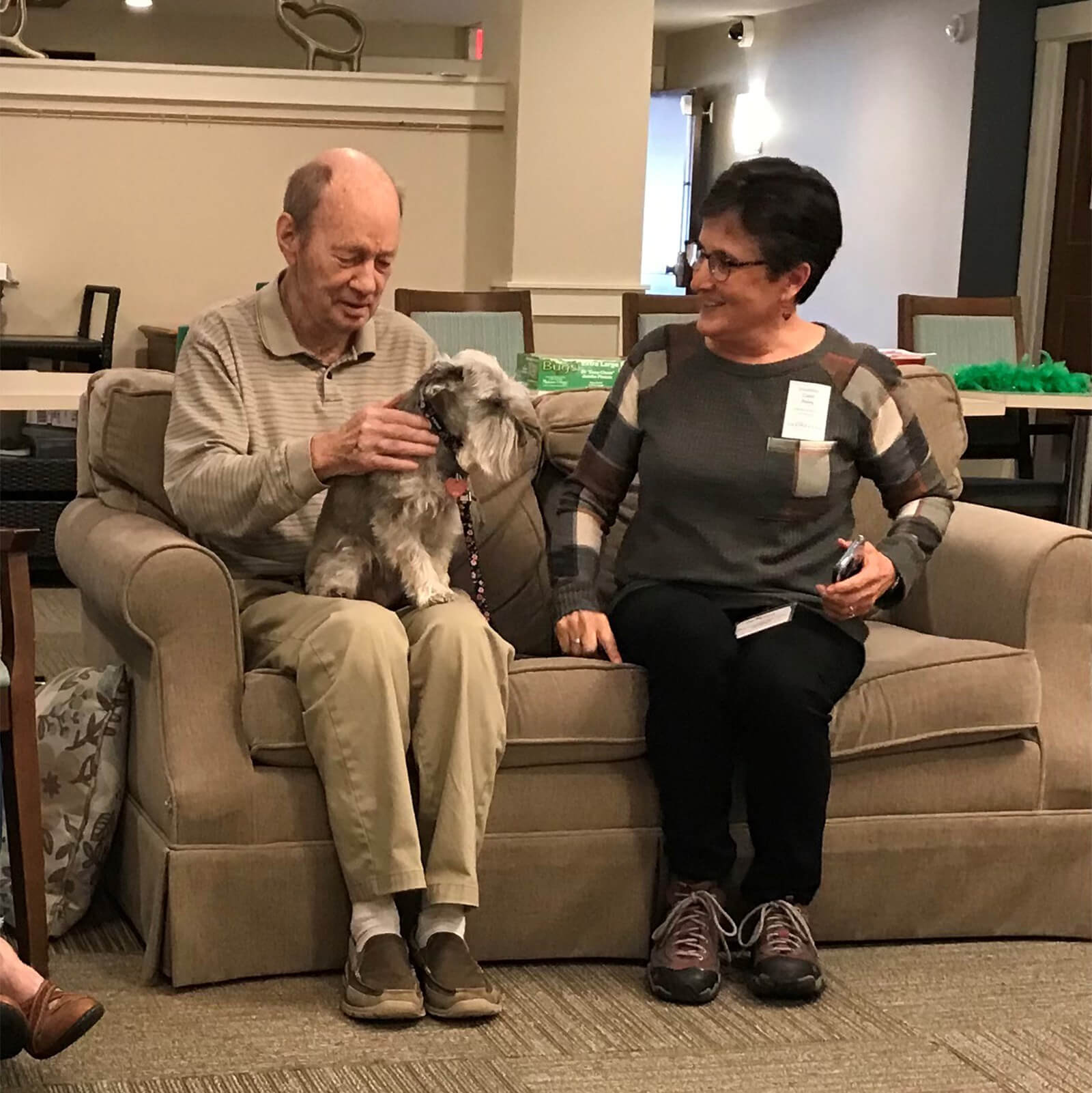 A heartwarming scene of pet therapy at The Waters on Mayowood, where a resident enjoys time with a visiting dog, emphasizing compassionate care.