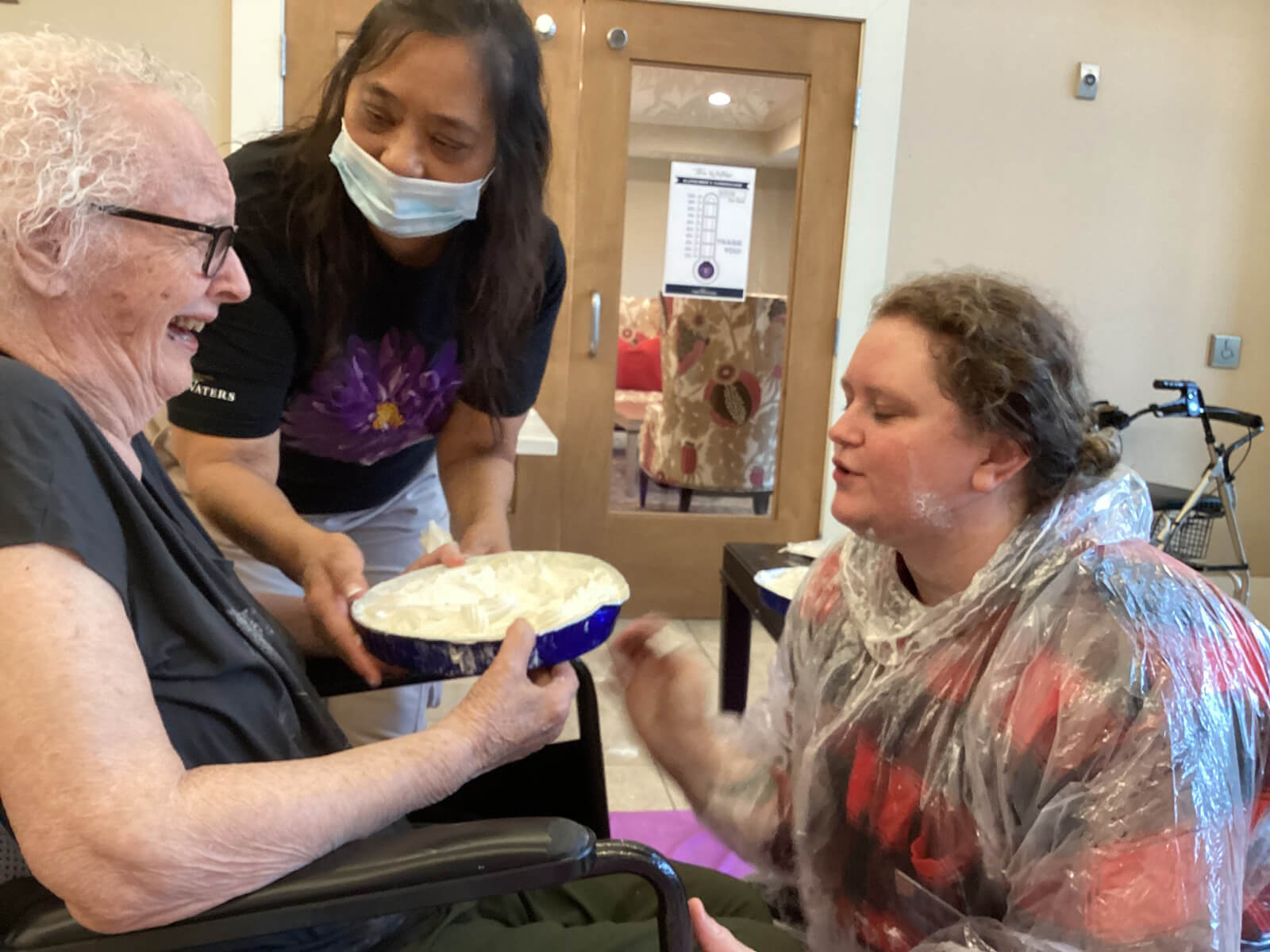 A fun and laughter-filled pie-in-the-face game at The Waters on 50th, highlighting the community's playful spirit.