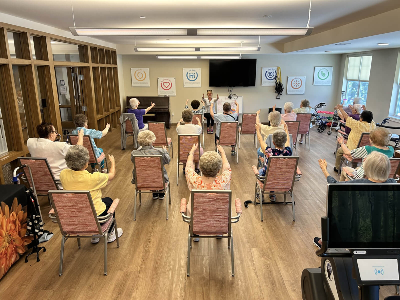 Residents at The Waters of Wexford participating in a seated fitness class, promoting active aging and wellness.