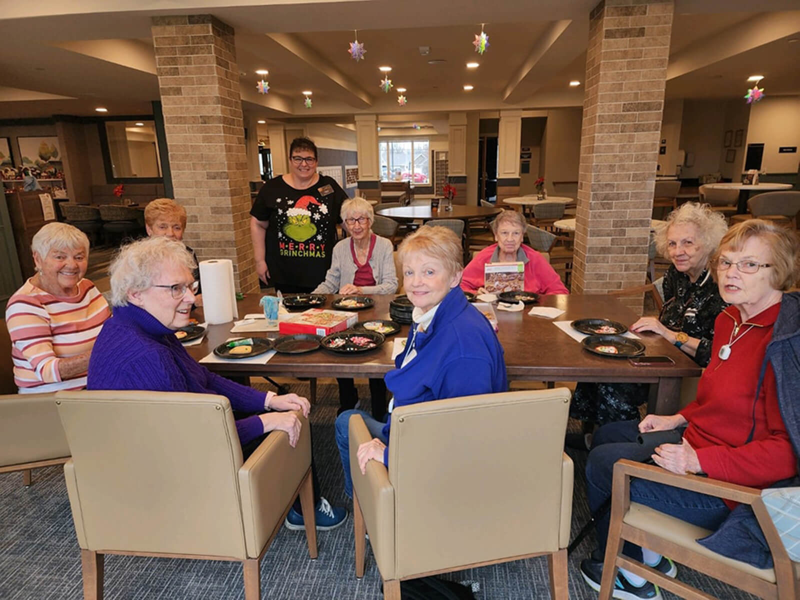Residents of The Waters of Pewaukee gathered around a table for a fun cookie decorating session, sharing smiles and creativity.