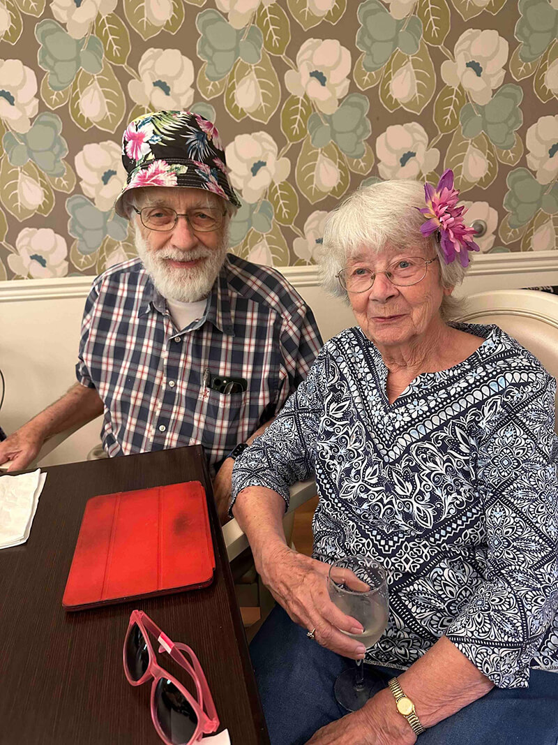 A joyful moment at The Waters of Oakdale's themed hat party, with residents showcasing their individual styles and personalities.